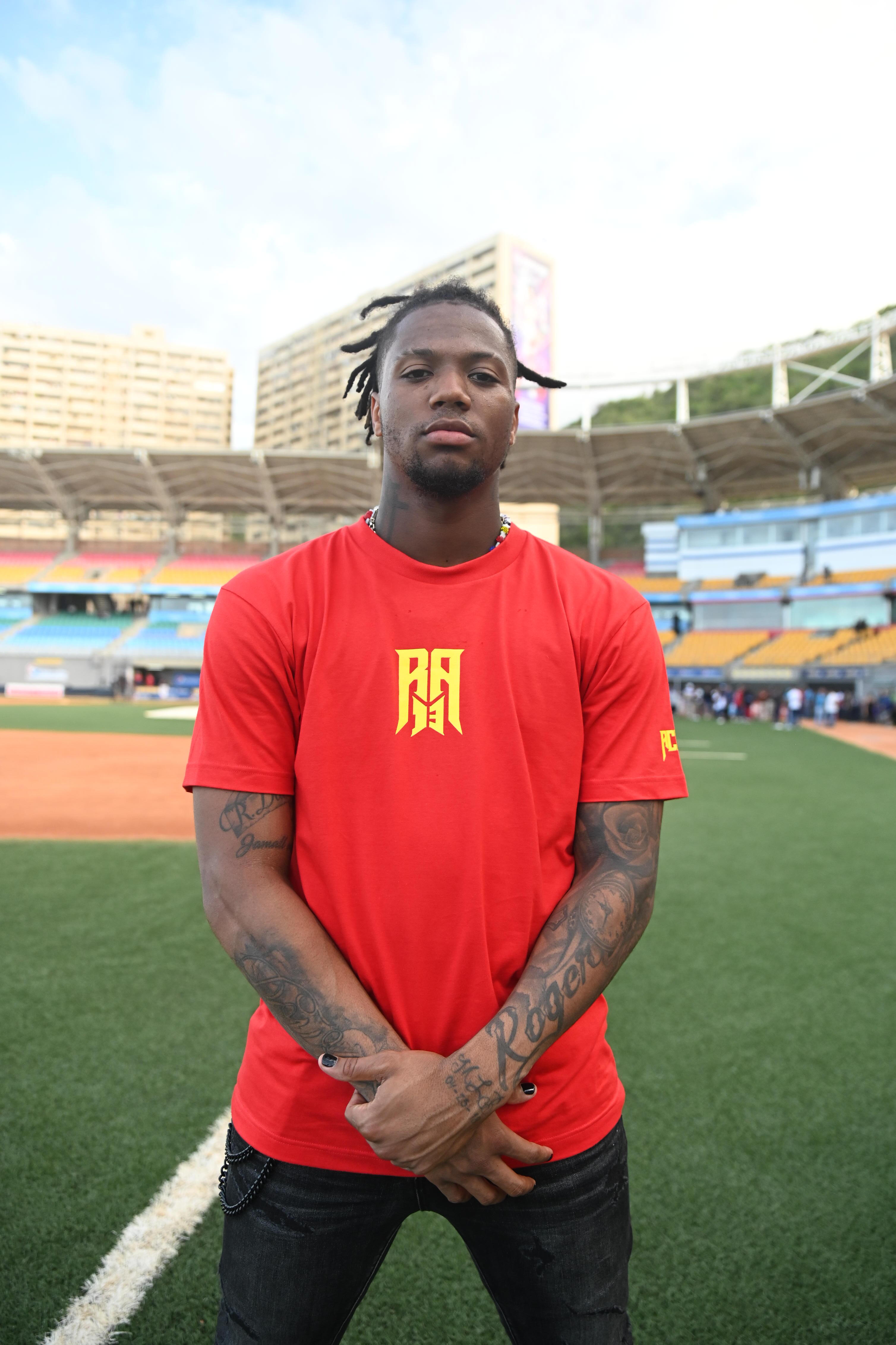 ronald-acuna-jr-pictured in the ra13 red tee with logo standing in a stadium in La Guaira, Venezuela