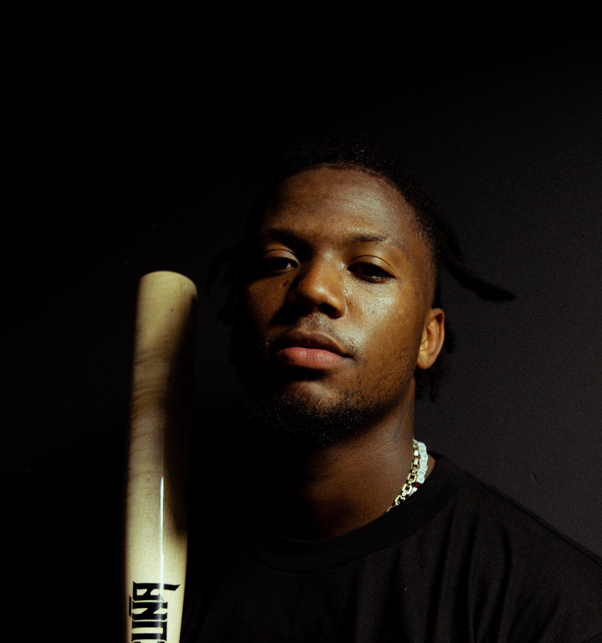 Ronald Acuña wearing a black tee shirt and holding a baseball bat with the "Acuña" logo on it